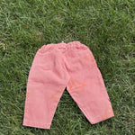 Pre-loved Unbranded coral star print pull-on pants, kids size 3T, back view, laid flat on grass
