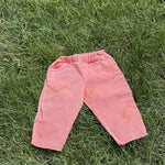 Pre-loved Unbranded coral star print pull-on pants, kids size 3T, front view, laid flat on grass