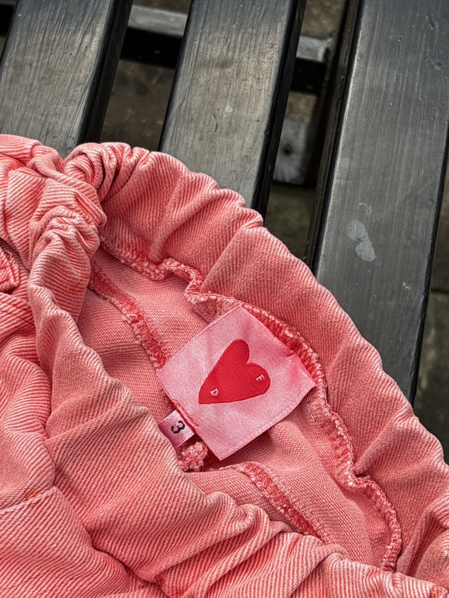 Pre-loved Unbranded coral star print pull-on pants, kids size 3T, brand and size label close-up