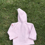 Pre-loved Widgeon pink polartec fleece hooded jacket, kids size 9M, back view, laid flat on grass